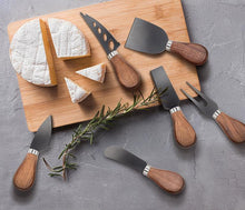 wooden cutting board with cheese knives