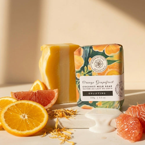 Orange Grapefruit coconut milk soap with packaging and citrus fruits on a light background