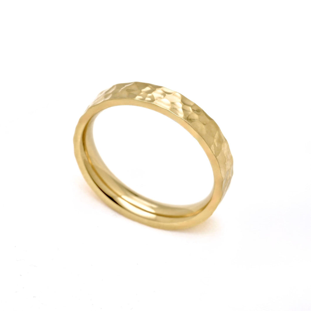 A gold band ring with a hammered textured exterior and a smooth polished interior, shown on a plain white background.