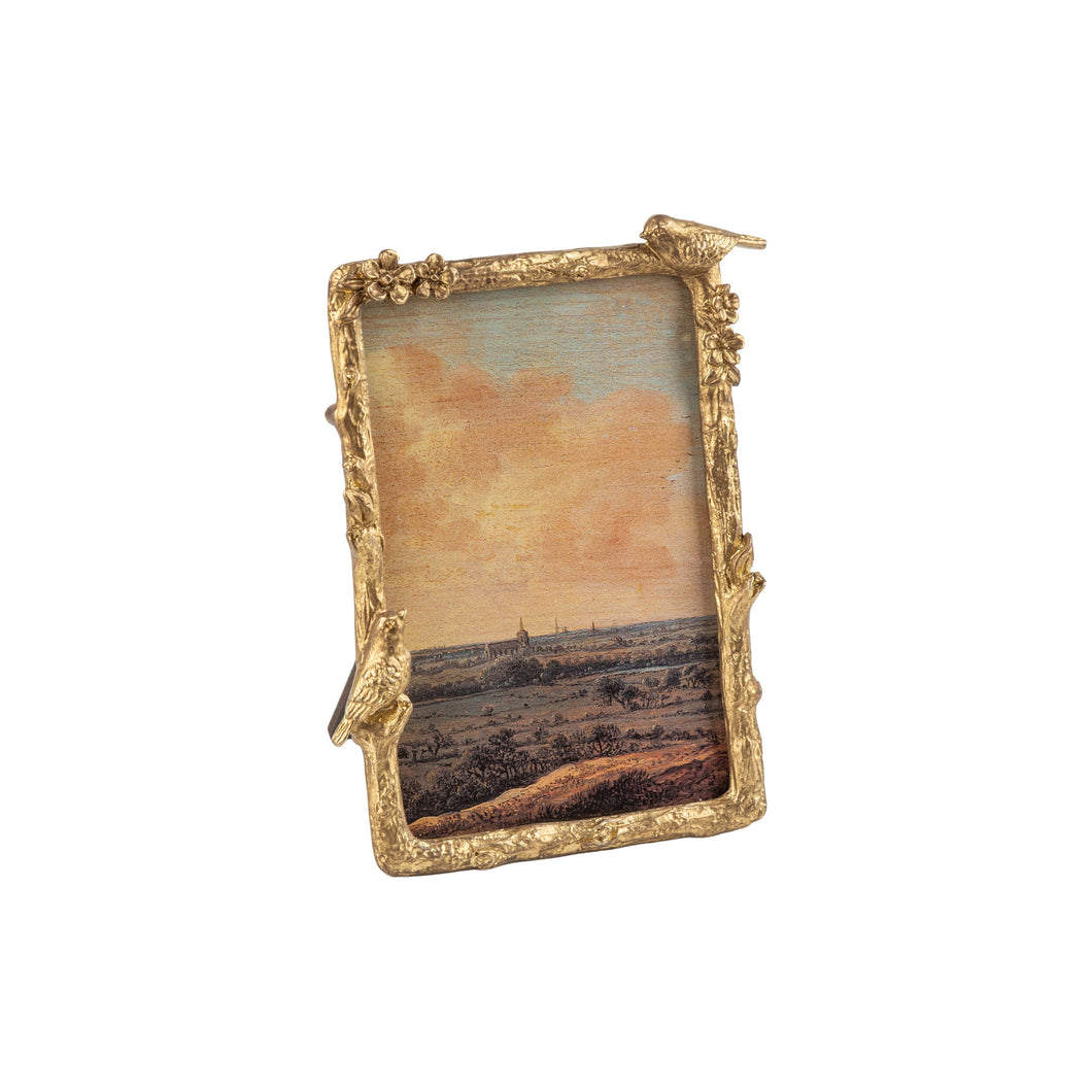 An ornate gold picture frame with sculpted details and bird perches on the corners, holding a small landscape painting, shown against a plain white background.