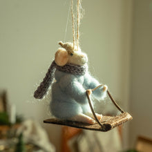 Plush toy mouse on a sled with a blurred background