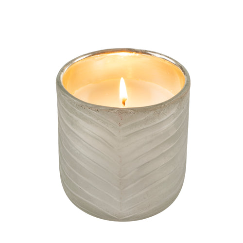 Candle in a textured glass holder on a white background