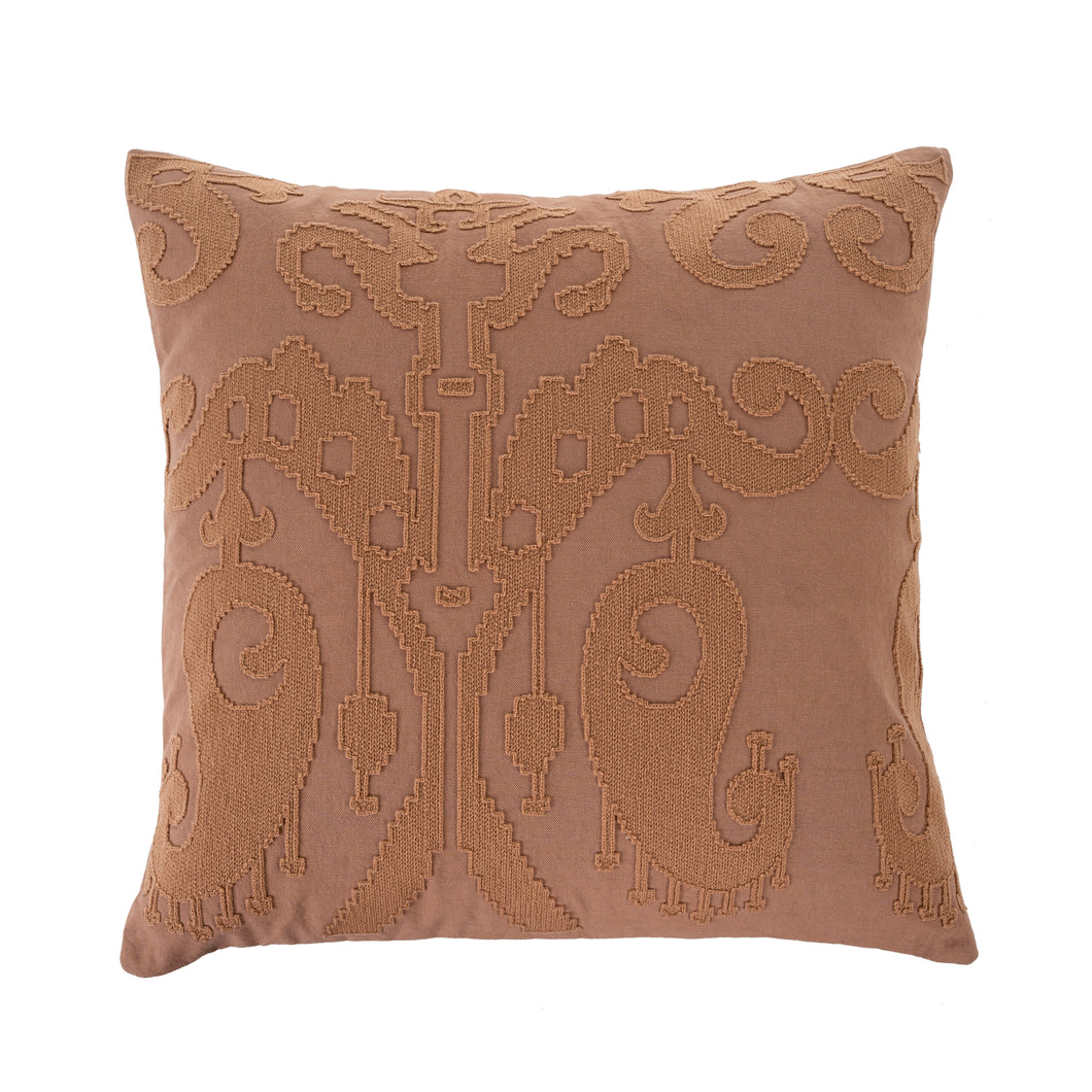 Rose coloured decorative pillow with intricate pattern on a beige background