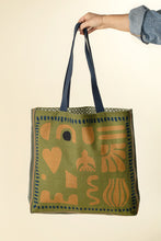 Green tote bag with ochre yellow floral print and blue handles