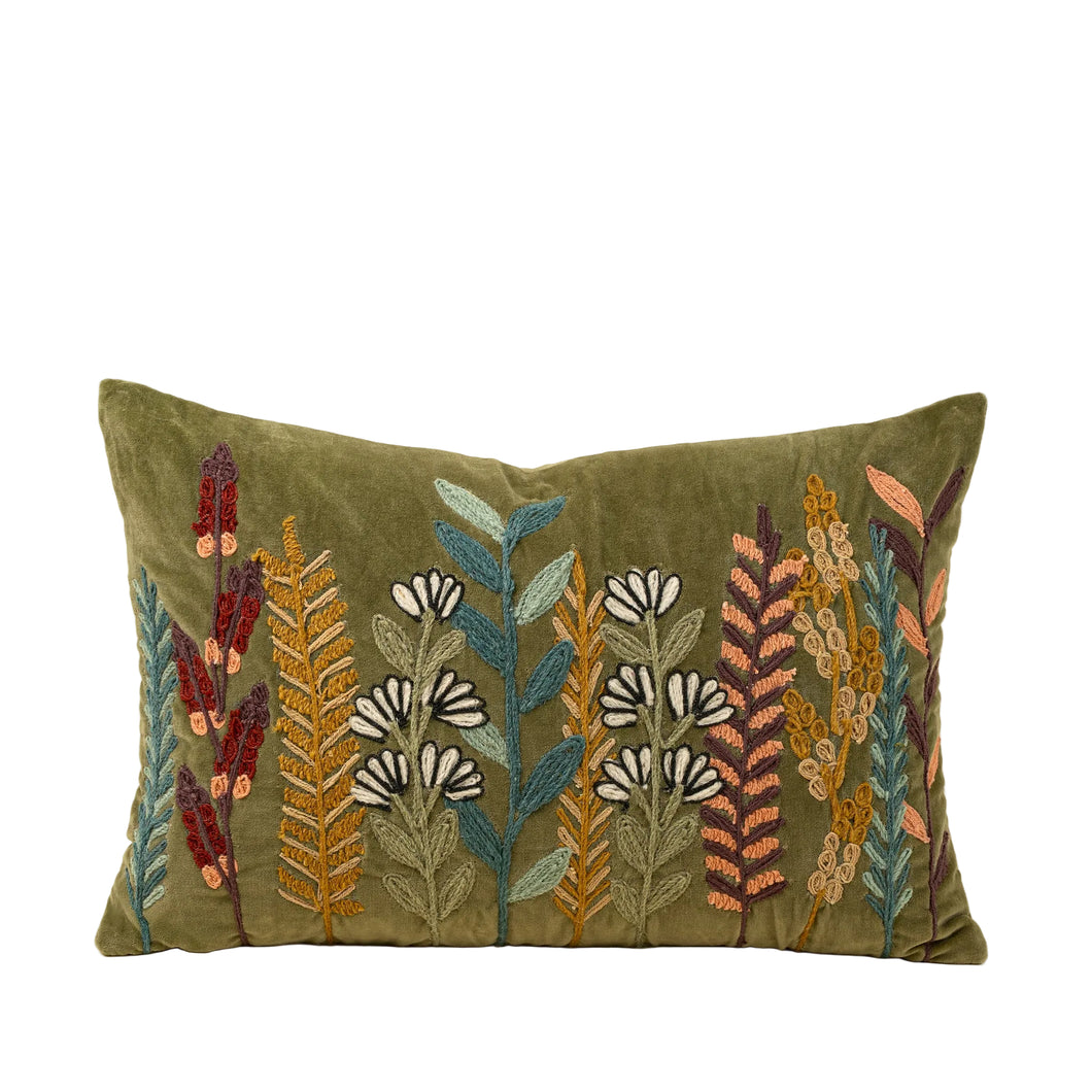 Green velvet cushion with brightly colored floral embroidery 
