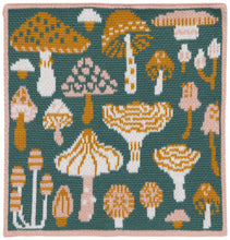 Patterned dishcloth with various stylized mushrooms on a green background