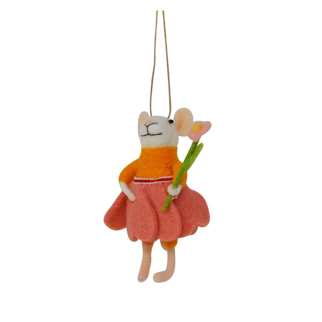 A felt mouse hanging ornament wearing an orange top and pink skirt, holding a green stem with a pink flower, suspended by a thin string against a plain white background.