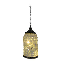 A hanging pendant light with a textured, illuminated glass shade featuring circular cutouts and ornate patterns, suspended by a dark metal chain against a plain white background.