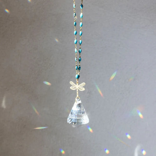 Crystal car hanging with dragonfly design on a gray background