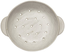 White ceramic colander with holes on a white background