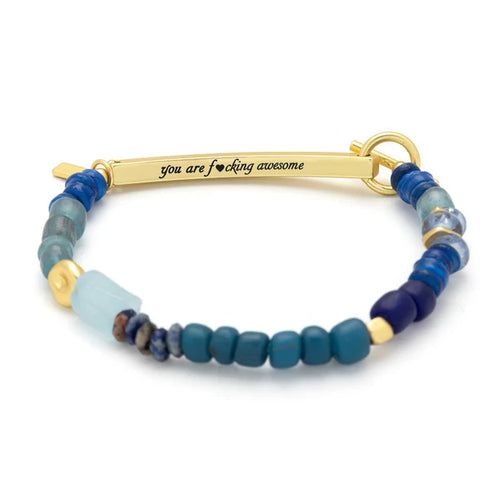 Bracelet with blue beads and gold clasp on a white background