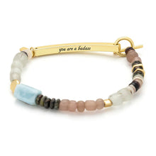Bracelet with beads and gold bar with 'you are a badass' text on a white background