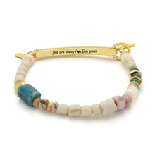Bracelet with gold clasp and multicolored beads on a white background