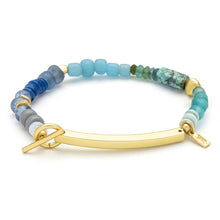 Bracelet with multicolored blue beads and gold clasp on a white background