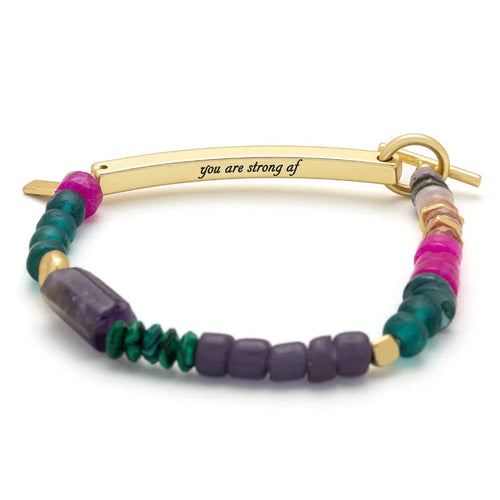 Multicolored beaded bracelet with a gold bar and 'you are strong af' engraving on a white background