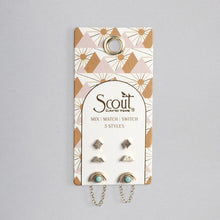 Packaged earring set with 'Scout' branding on a gray background