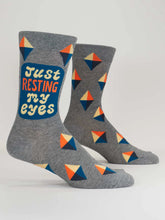 Gray socks with geometric pattern and 'Just Resting My Eyes' text on a white background