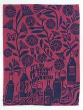 Decorative towel with floral and wine-themed design on a pink background