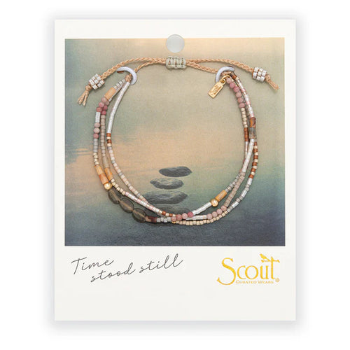 Bracelet with stones on a scenic background, featuring the phrase 'time stood still' and 'Scout' brand.