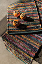 Colorful textured table runner with persimmons on a neutral background