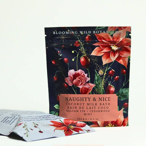 Blooming Wild Botanics Naughty & Nice Coconut Milk Bath packet standing upright, with two smaller sachets placed in front on a plain white background.