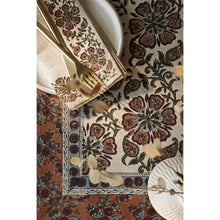 Decorative tablecloth flat lay with floral pattern and matching napkin
