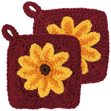 Two maroon crochet dish scrubbers with yellow flower designs on a white background