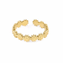 A gold-toned open band ring featuring a continuous row of small flower or daisy motifs, shown on a plain white background.