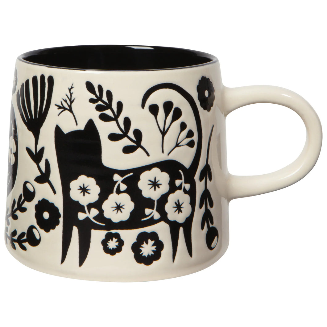 Ceramic mug with black and white floral and cat design on a white background
