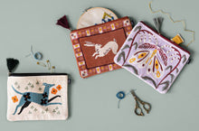 Decorative pouches with animal designs on a gray background