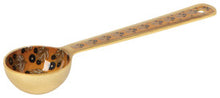 Decorative gold spoon with intricate patterns on a plain background