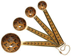 Set of vintage-style measuring spoons with decorative handles on a white background